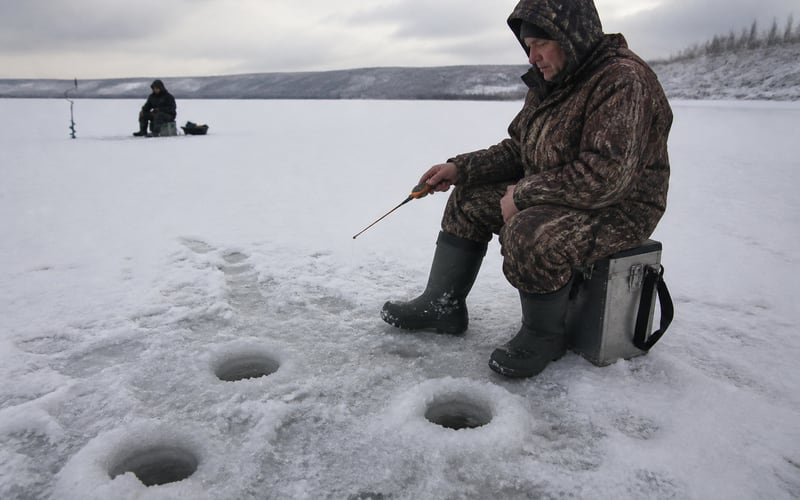 Зимняя рыбалка: лунки на льду водохранилища